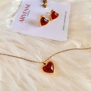 Gold heart shaped Carnelian crystal necklace and gold heart shaped carnelian crystal earrings located on a plaque with the LilAryenne logo.