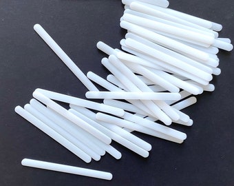 May include: A pile of white plastic sticks, likely for crafts or DIY projects.