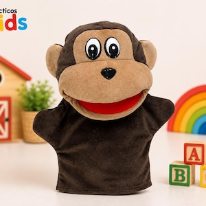 May include: A plush monkey hand puppet with dark brown fur, a light tan face, large white eyes with black pupils, a black nose, and a bright red mouth. The text Didácticos Kids is visible in the upper left corner of the image.