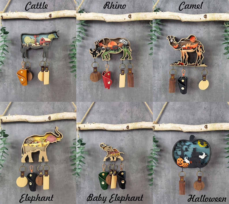 May include: Wooden keychains with animal silhouettes and scenic backgrounds. The animals include a cow, rhino, camel, elephant, baby elephant, and a Halloween themed design. Each keychain has a leather loop and a metal ring.