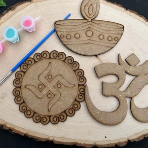 May include: A wooden craft kit featuring three unfinished wooden shapes: a diya, an Om symbol, and a swastika. The kit includes three small bottles of paint and a paintbrush.