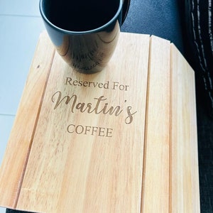 May include: A wooden tray with the text "Reserved For Martin's Coffee" engraved on it. A black coffee mug is sitting on the tray.