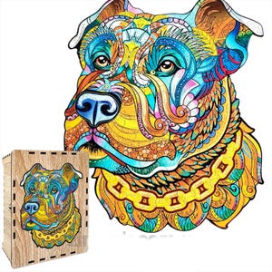 Puede incluir: Un colorido rompecabezas de madera con la imagen de una cabeza de perro estilizada con intrincados patrones en tonos azules, amarillos, naranjas y verdes. El rompecabezas est&aacute; junto a su caja de madera, que tiene la imagen del rompecabezas impresa.