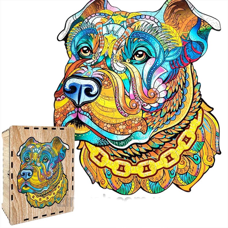 Puede incluir: Un colorido rompecabezas de madera con la imagen de una cabeza de perro estilizada con intrincados patrones en tonos azules, amarillos, naranjas y verdes. El rompecabezas est&aacute; junto a su caja de madera, que tiene la imagen del rompecabezas impresa.