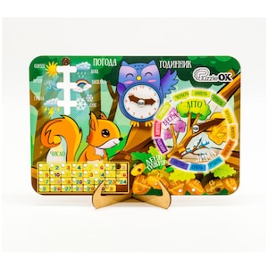 Puede incluir: Un juguete educativo de madera colorido con un calendario, un reloj, el clima y las estaciones. El juguete presenta una ardilla, un búho y un árbol con diales giratorios.