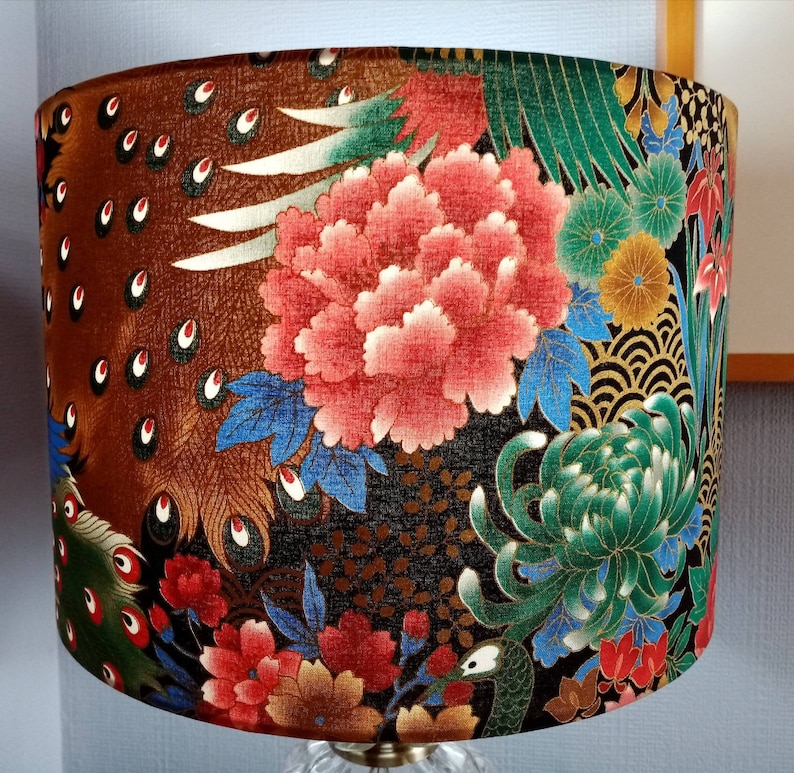 May include: A lampshade with a dark brown background and a colorful floral pattern. The pattern includes red, pink, green, and gold flowers, as well as peacock feathers.