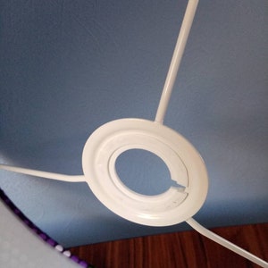 May include: White lampshade fitting with a blue fabric lampshade. The lampshade has a purple and green trim.