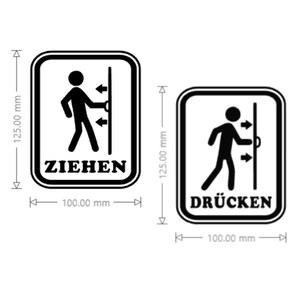 Può includere: Due cartelli per porte in bianco e nero. Uno dice "ZIEHEN" (tirare) e mostra un omino che tira una porta. L'altro dice "DRÜCKEN" (spingere) e mostra un omino che spinge una porta. Ogni cartello è alto 12,5 cm e largo 10 cm.