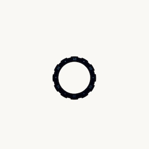 May include: A black watch bezel with a circular design. The bezel features a series of notches around the outer edge and is marked with numbers at intervals of 10, from 10 to 60. The numbers are in a lighter shade of black.