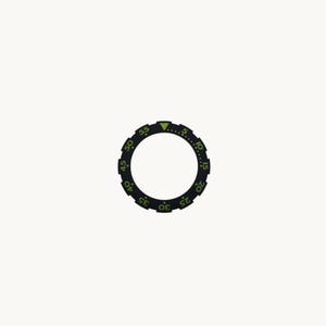 May include: A black watch bezel with green markings and a green triangle at the top. The bezel has numbers and markings for time increments. The design is circular and set against a white background.