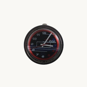 May include: A round black watch with a red and black face. The watch face has white hands and the word "POP" is visible. The numbers 5, 6, 7, 8, 9, 10, 11, and 12 are visible in red.