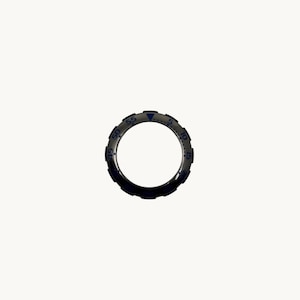 Peut inclure: Une bague argentée avec un bord extérieur bleu foncé et des marquages bleus. La bague comporte des chiffres et des repères sur la circonférence, avec un repère triangulaire en haut. La bague est circulaire et semble être une lunette de montre.