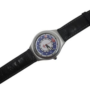 May include: A silver-toned wristwatch with a black leather band. The watch face features a white center with blue and red accents, including the numbers 1 through 12. The watch band has a silver buckle.