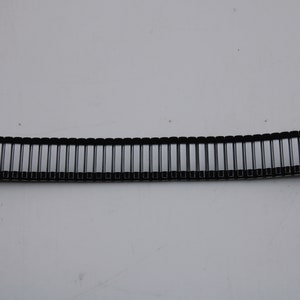 May include: A silver and black watch band with a metal clasp.