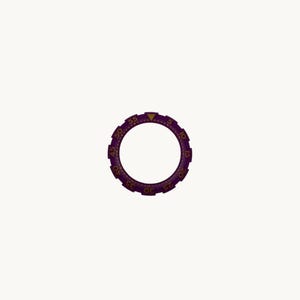 May include: A purple watch bezel with gold-colored numerals and markers. The bezel has a circular design with a series of numbers from 5 to 55, and a triangle marker at the top. The bezel is designed to fit around a watch face.