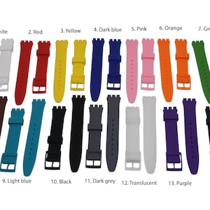 Op de afbeelding: Een set van 14 verschillende gekleurde siliconen horlogebandjes. De bandjes zijn allemaal dezelfde maat en stijl, en ze zijn gerangschikt in twee rijen van zeven. De kleuren zijn wit, rood, geel, donkerblauw, roze, oranje, groen, donkerbruin, lichtblauw, zwart, donkergrijs, doorschijnend, paars en donkerblauw.