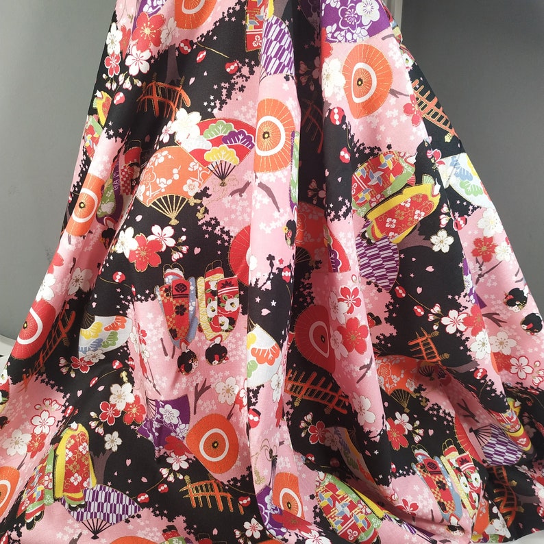 Cotton Cosmo fabric with maiko figures on a black background
