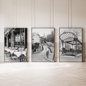 Könnte beinhalten: Set aus drei gerahmten Schwarz-Weiß-Drucken. Einer zeigt ein Pariser Café mit Außensitzplätzen, ein weiterer eine Kopfsteinpflasterstraße zu einer Kirche und der dritte einen Vintage-U-Bahn-Eingang.