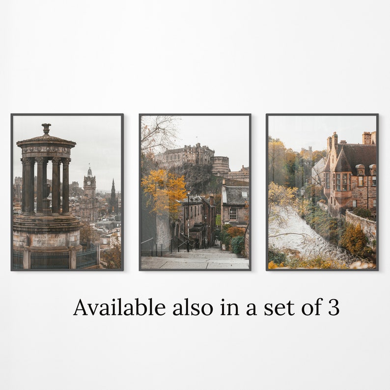 May include: A set of three framed prints featuring scenic views of Edinburgh, Scotland. The first print shows a stone monument with a view of the city skyline. The second print shows a cobblestone street with a view of Edinburgh Castle. The third print shows a cobblestone street with a view of a historic building.