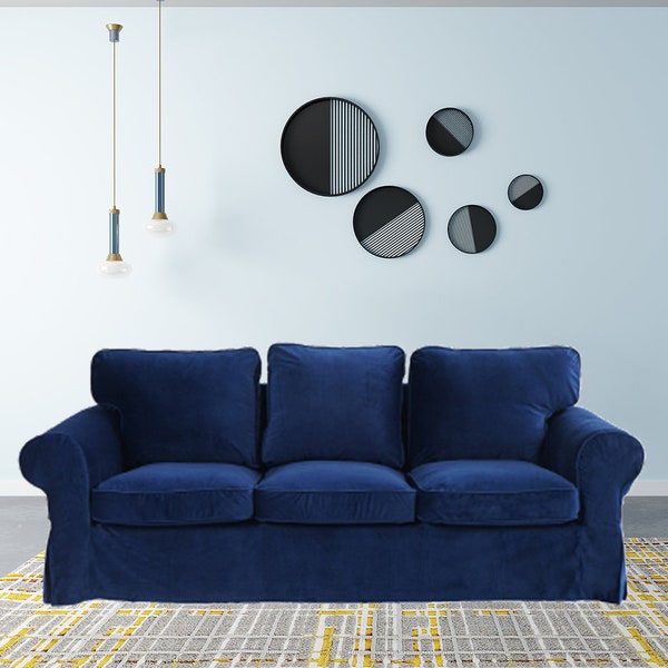 May include: A dark blue velvet sofa with three cushions and a light grey and yellow patterned rug underneath.