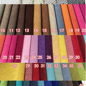 May include: A swatch card of 48 different colors of grain fleece fabric. The colors range from white to black and include shades of brown, pink, purple, yellow, green, blue, and red. The fabric is numbered from 950-1 to 48.