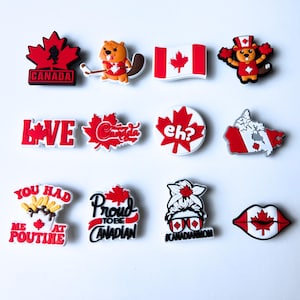 May include: A set of 12 Canadian-themed shoe charms. The charms feature various designs including a maple leaf, a beaver, a Canadian flag, the words "Love Canada", "Eh?", "You Had Me At Poutine", and "Proud To Be Canadian".