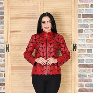 May include: A red leather jacket with a black leaf pattern. The jacket has a zip fastening and a stand-up collar.