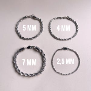 Peut inclure: Quatre bracelets chaîne en argent avec des épaisseurs variables. Les tailles sont indiquées : 5 mm, 4 mm, 7 mm et 2,5 mm. Chaque bracelet est doté d'un fermoir. Présentation sur fond clair.