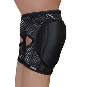 May include: Black knee pad with a honeycomb pattern and thick black padding. The knee pad has the word "QUEEN" printed on it.