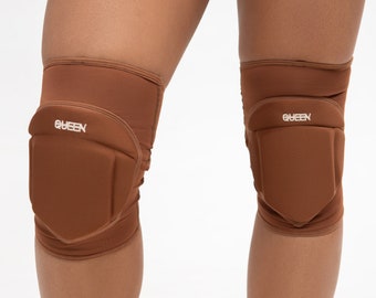 May include: A pair of brown knee pads with the word "QUEEN" printed on each pad.