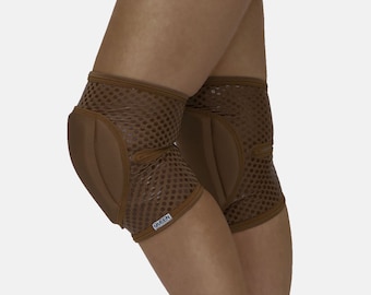 May include: A pair of brown knee pads with a mesh design and a padded section on the front. The knee pads have a black label with the word "GREEN" on them.