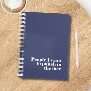 May include: A blue spiral bound notebook with the text "People I want to punch in the face" printed in white on the cover.
