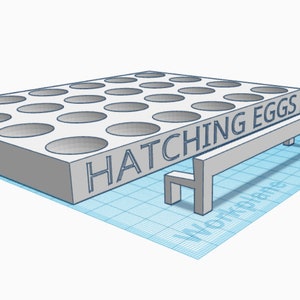 May include: A white plastic egg incubator with 25 round holes and the text "HATCHING EGGS" on the front. A small white bench is in front of the incubator.