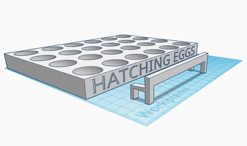 May include: A white plastic egg incubator with 25 round holes and the text "HATCHING EGGS" on the front. A small white bench is in front of the incubator.