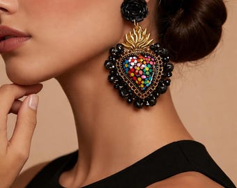 May include: Black heart-shaped earrings with colorful dot accents and gold-colored flame details. The earrings have a black rose stud and are adorned with black beads. A unique and eye-catching accessory.