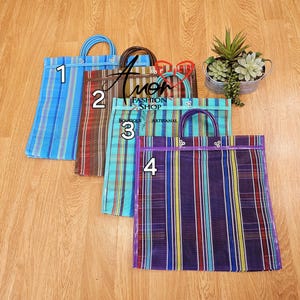 Op de afbeelding: Vier kleurrijke netten boodschappentassen met handvatten. De tassen zijn blauw, bruin, groen en paars. De tassen zijn genummerd van 1 tot 4. De tekst "Fashion Shop Boutique Artesanal" is zichtbaar op de tassen.