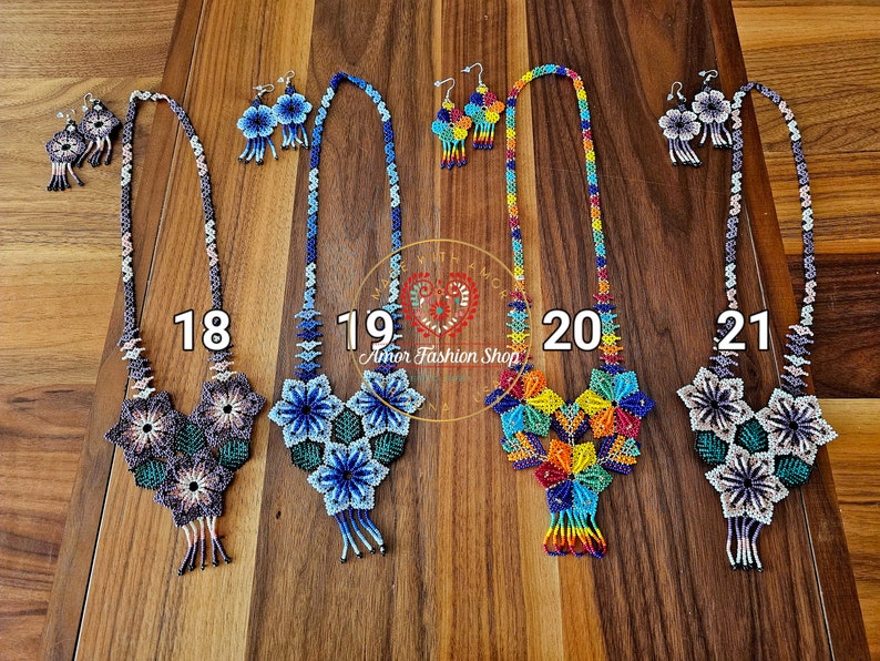 May include: Four sets of beaded necklaces and matching earrings labeled 18, 19, 20, and 21. Each set features intricate floral patterns made of small colorful beads. The designs include geometric shapes, hanging fringe details, and long beaded chains.