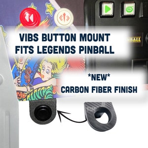 May include: A black button mount for pinball machines with a carbon fiber finish. The mount is labeled "VIBS BUTTON MOUNT FITS LEGENDS PINBALL *NEW* CARBON FIBER FINISH".