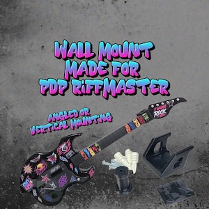 May include: A black wall mount for a PDP RiffMaster guitar controller, including mounting hardware, screws, and anchors. The text reads WALL MOUNT MADE FOR PDP RIFFMASTER and ANGLED OR VERTICAL MOUNTING. The guitar features colorful 80s-style decals.