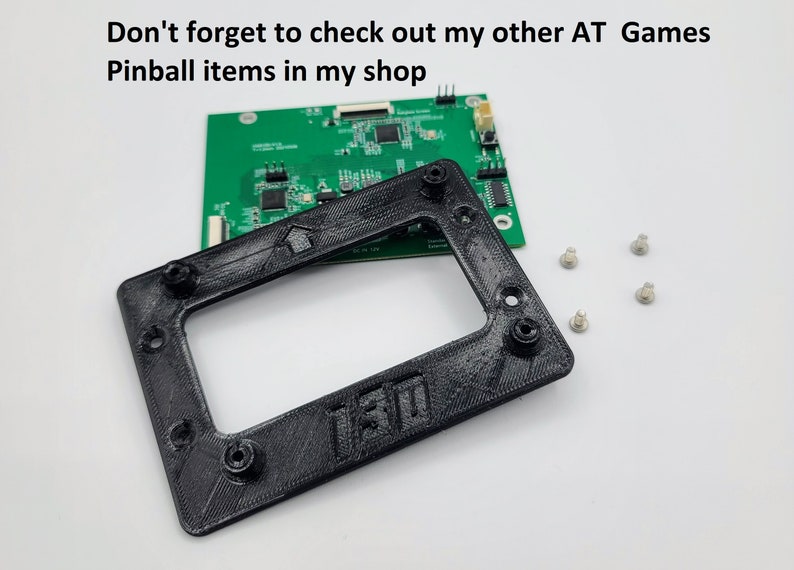 May include: A black plastic frame with a cutout for a screen. The frame has four screw holes and the text "130" is visible on the bottom. There are four small silver screws on a white surface.