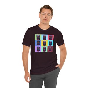 May include: A dark maroon t-shirt with a colorful graphic print of nine tomato soup cans. Each can has a different colored background.