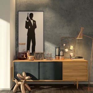 May include: A wooden sideboard with a black top and three drawers. The sideboard has a copper-colored metal drink dispenser with the text "Just Drink Happy Hour" on it. There are also copper-colored metal candle holders, a wire basket, and a book on top of the sideboard. A copper-colored balloon animal is in the foreground.