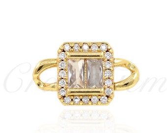 May include: Gold ring featuring a square clear stone set in a pave setting. The ring has a plain band.
