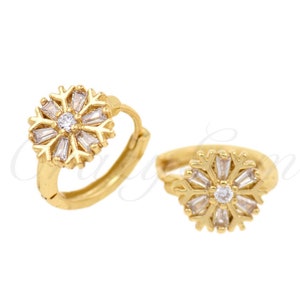 May include: Gold hoop earrings with a small, clear crystal snowflake design.
