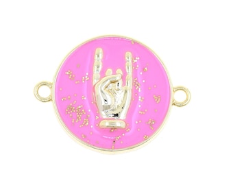 Puede incluir: Un charm circular rosa con purpurina dorada y una mano de metal dorado haciendo el gesto de rock and roll.