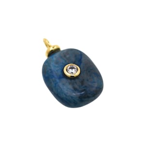 May include: A blue stone pendant with a gold-colored bail. The pendant has a small, round, clear stone set in a gold-colored bezel. The stone is a rounded, irregular shape.
