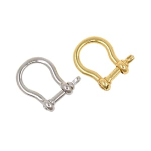 May include: Two metal shackle clasps, one silver and one gold, are displayed against a white background. The clasps have a U-shape with a screw pin closure. These are commonly used in jewelry making and leathercraft.