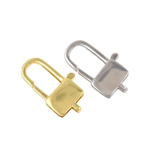 May include: Two metal clasp closures, one gold-toned and one silver-toned, are displayed against a white background. Each clasp has a rectangular body with a curved top and a small, protruding tab.