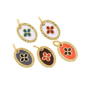 Puede incluir: Cinco colgantes ovalados dorados con diseños de flores de esmalte de colores. Cada colgante tiene un borde dorado y un lazo para sujetarlo a una cadena o pulsera. Los colores de las flores incluyen turquesa, rojo, negro, marrón y naranja.