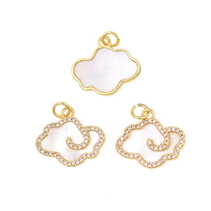May include: Three gold cloud charms featuring white enamel and clear rhinestones. The charms are ideal for jewellery making or adding a touch of whimsy to any project.